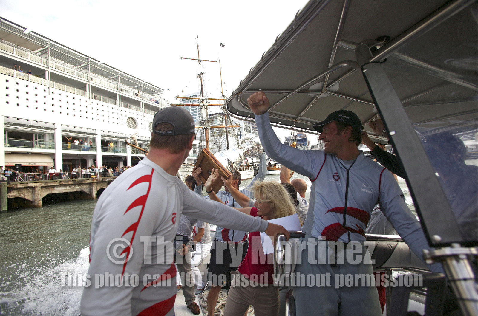 03_1502D ©Th.Martinez - Auckland (NZ) . America's Cup 2003. 2nd March 2003.Alinghi Team winner of America's Cup 2003..Ernesto Bertarelli driving the boat , on the way back from the Post America's Cup press conference to the Alinghi Base..Jochen Schuemann is showing The CUP to the public...