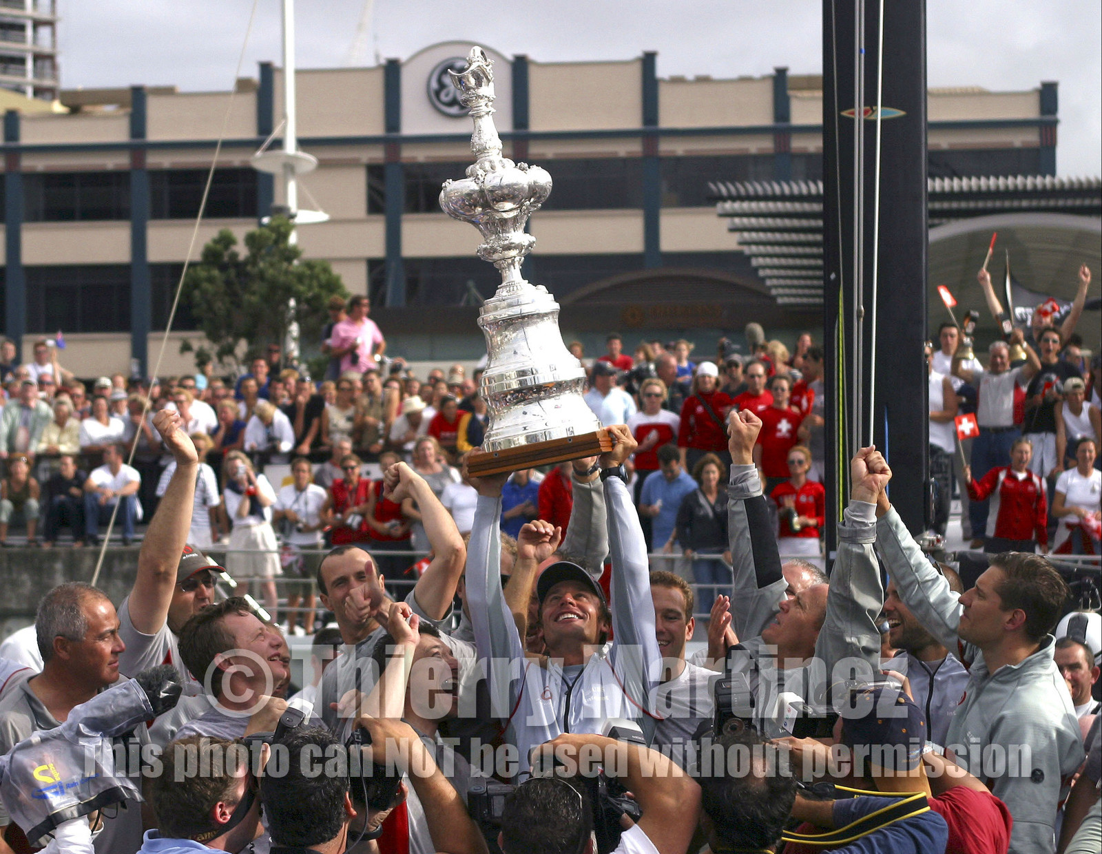 03_1504D ©Th.Martinez - Auckland (NZ) . America's Cup 2003. 2nd March 2003.Alinghi Team winner of .America's Cup 2003. Docking ceremony. Ernesto Bertarelli (Alinghi's President and navigator) holding up The Cup and sharing .the victory with Alinghi Team...