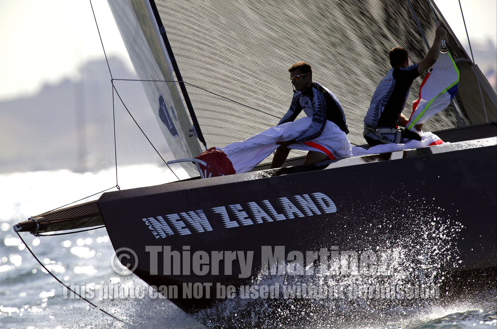 03_0215D ©Th.Martinez - Auckland (NZ) . America's Cup 2003. 18th February 2003. Day 2..Alinghi (SUI 64) vs Team NZ (NZL 82) .NZL 82 's crew setting up spinnaker and leading  SUI 64 at mark 3. Alinghi will over take Team NZ in the last leg and win with 7s on Team NZ.....