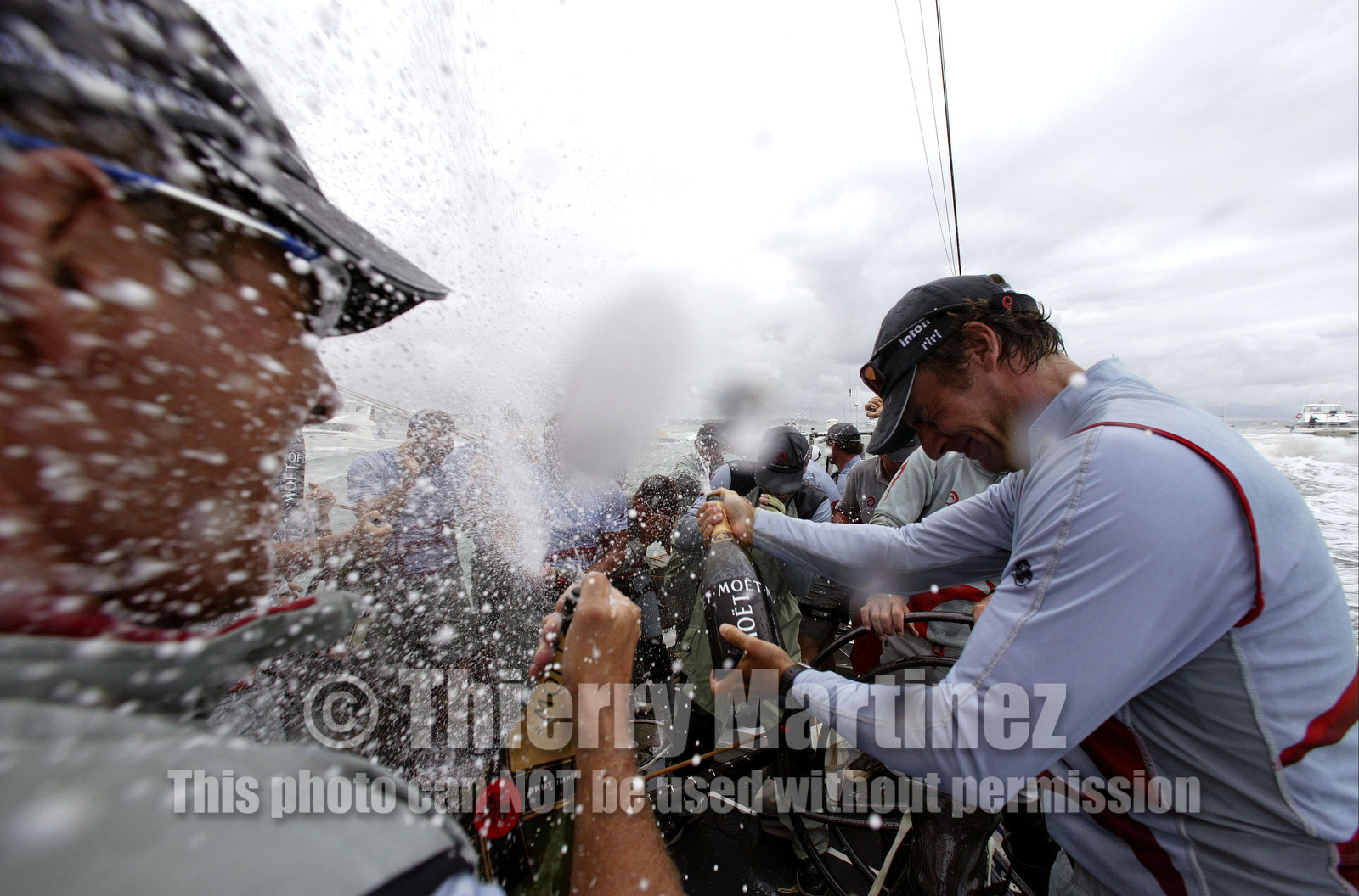 03_1403D © Th.Martinez . Auckland   New Zealand. 2nd March 2003 America's Cup 2003. Day 5, Alinghi (SUI64) vs Team New Zealand (NZL82). Alinghi winner of the 31st America's Cup. Champagne on board for Alinghi Team after Victory .