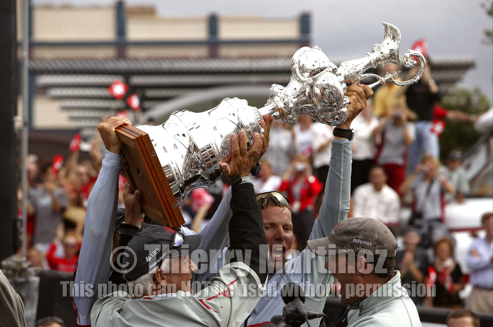 03_1423D © Th.Martinez . Auckland   New Zealand. 2nd March 2003 America's Cup 2003. Day 5, Alinghi (SUI64) vs Team New Zealand (NZL82). Alinghi winner of the 31st America's Cup (5-0). Docking ceremony, presentation of the America's Cup in the Viaduct Bassin. .Brad Butterworth, Jochen Schuemann, and Russell Coutts, holding The America's Cup.