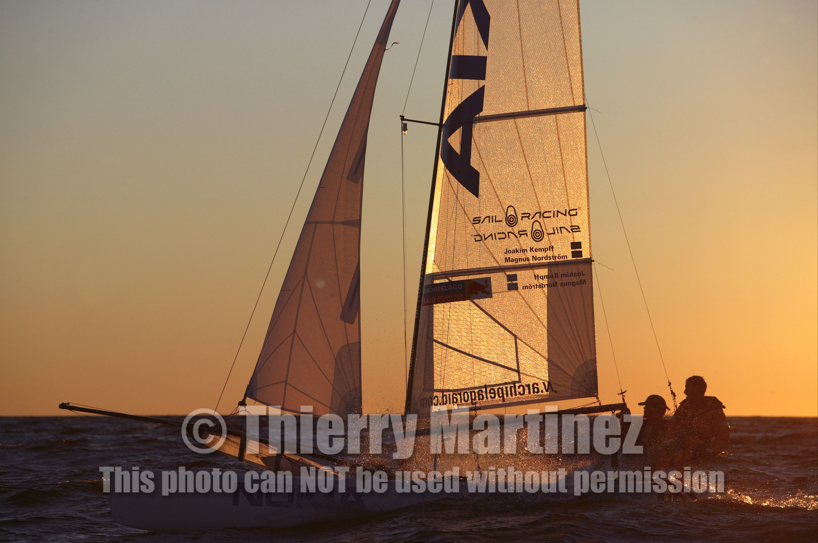 03_3247D© Th.Martinez,STOCKHOLM ARCHIPELAGO SWEDEN, 10 07 03-Archipelago Raid (2003)  Day 3..Team NOKIA-Kempff  Magnus Nordstrom (SWE)& Joakim Kempff (SWE) sailing in sunset light on the way back from Finland to Sweden.
