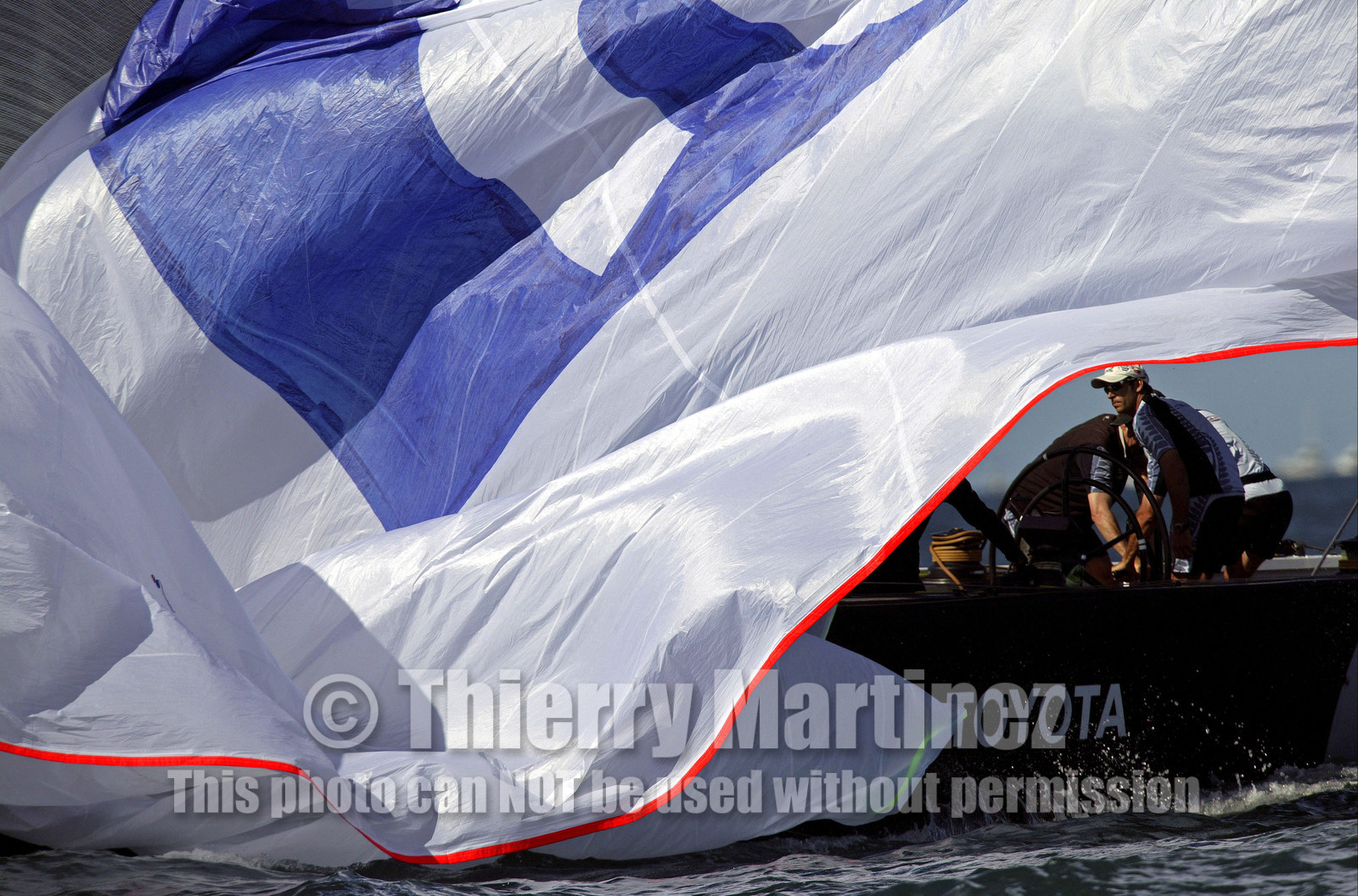03_0210D ©Th.Martinez - Auckland (NZ) . America's Cup 2003. 18th February 2003. Day 2..Alinghi (SUI 64) vs Team NZ (NZL 82) .Hammish Pepper (Tactician) behing the spinnaker droping down by NZL 82 crew...